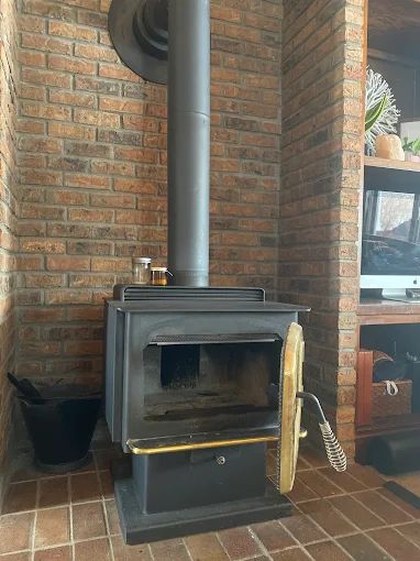 Wood-burning stove set into a stone fireplace