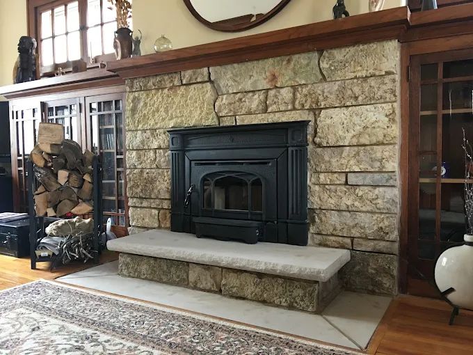 Wood stove in a stone fireplace